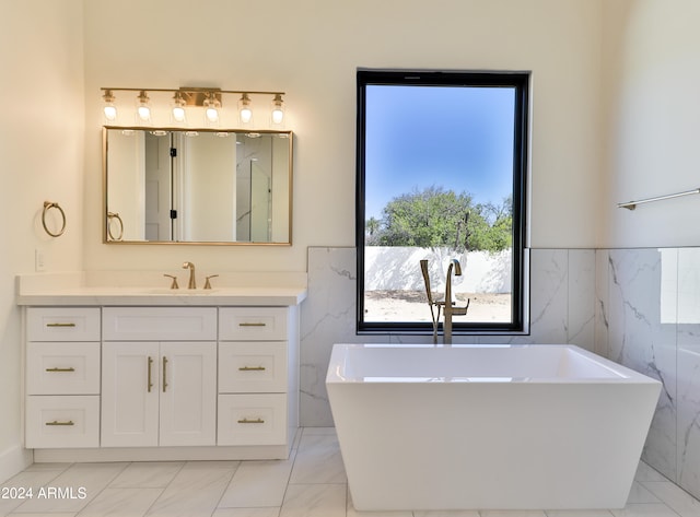 bathroom featuring vanity, tile walls, and a bath