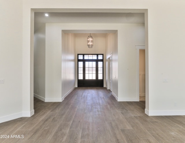 foyer with hardwood / wood-style floors and an inviting chandelier