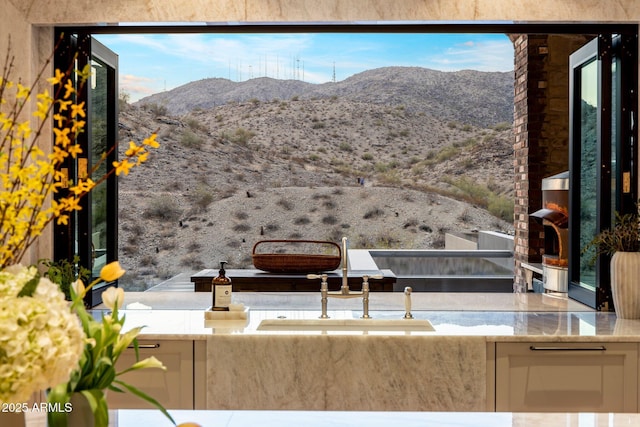 view of patio with a balcony, a mountain view, and sink