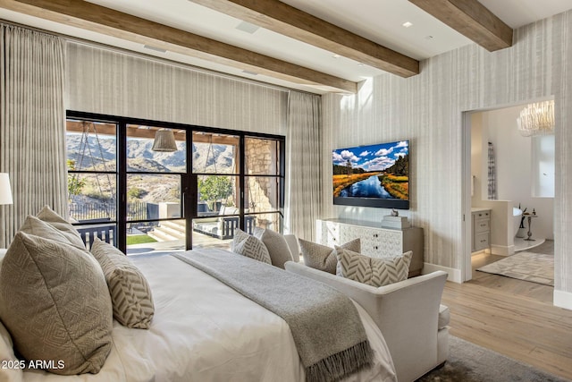 bedroom featuring an inviting chandelier, light hardwood / wood-style flooring, and beamed ceiling