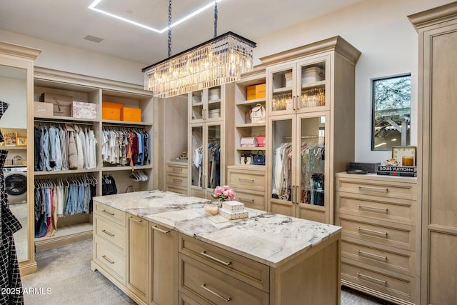 spacious closet featuring washer / clothes dryer and light colored carpet