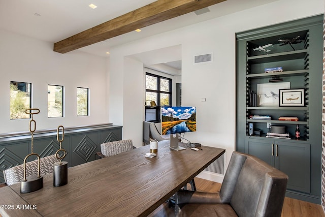 dining space with beamed ceiling and hardwood / wood-style floors