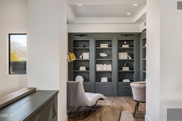 interior space featuring light hardwood / wood-style floors and a tray ceiling