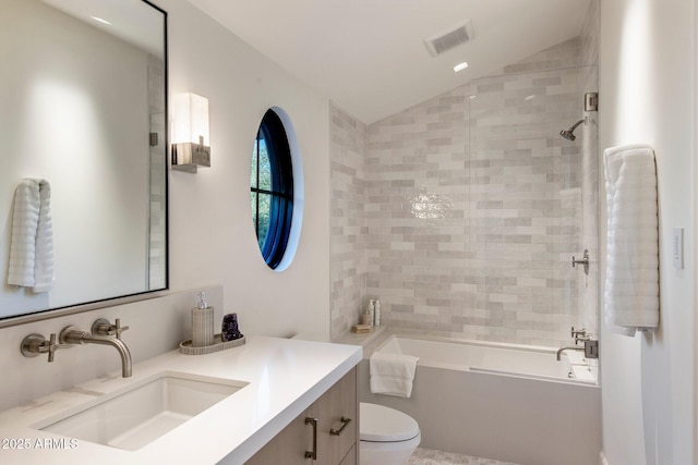 full bathroom with tiled shower / bath combo, vanity, lofted ceiling, and toilet