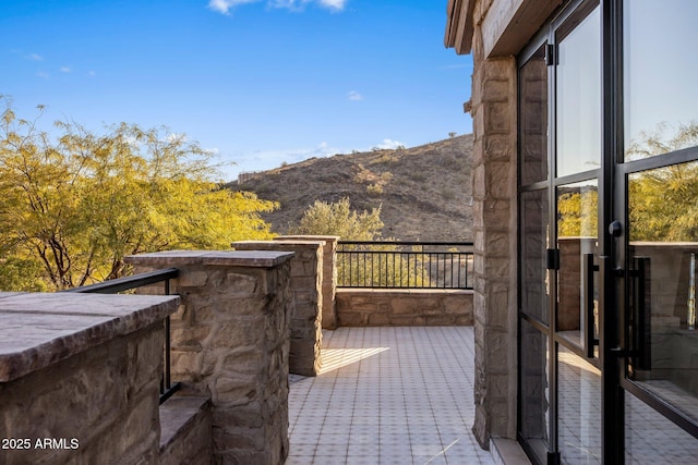 view of patio with a balcony and a mountain view