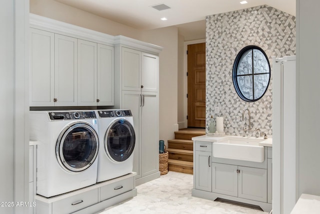 laundry room featuring cabinets, washer and dryer, and sink