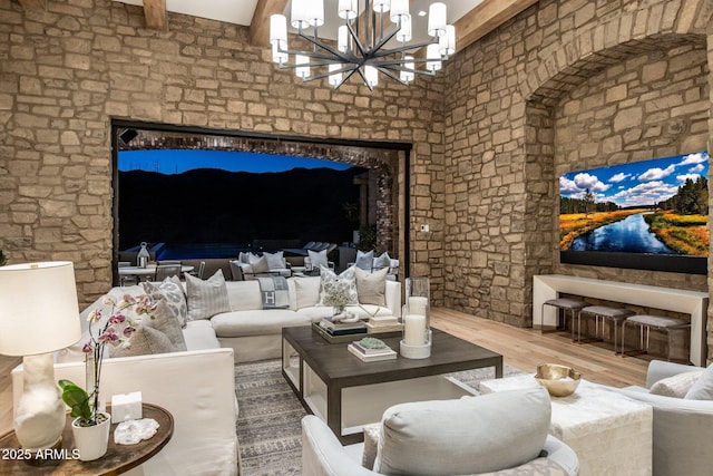 living room with hardwood / wood-style floors, a notable chandelier, and beamed ceiling