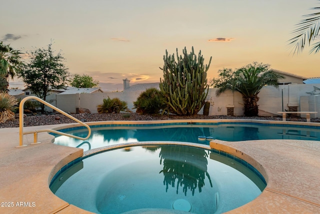 462 N Bedford Ct, Chandler, AZ 85225 - pool at dusk featuring a pool with connected hot tub and a fenced backyard