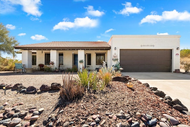 view of front facade featuring driveway, an attached garage, a tiled roof, and stucco siding