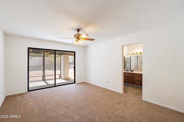 unfurnished bedroom with access to exterior, light colored carpet, ensuite bath, and baseboards