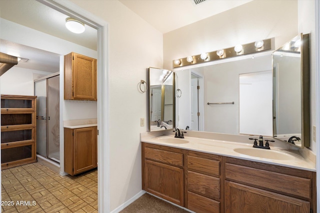 bathroom featuring a sink, a shower stall, baseboards, and double vanity