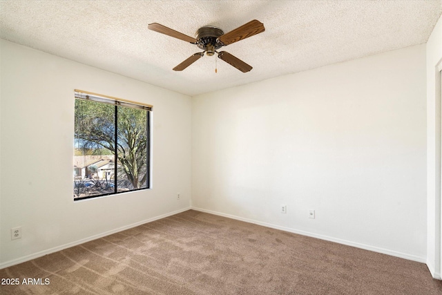 carpeted spare room featuring ceiling fan, baseboards, and a textured ceiling