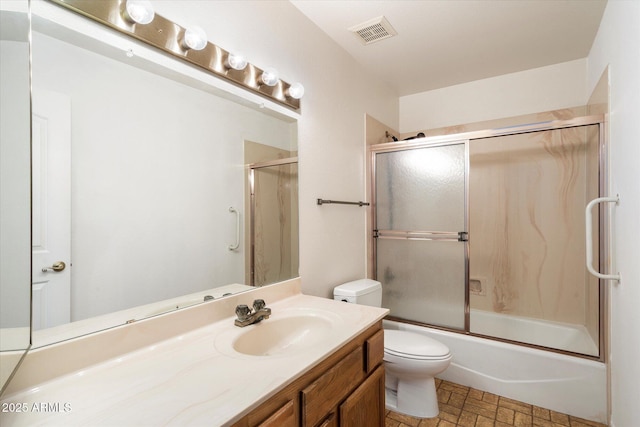 bathroom featuring visible vents, shower / bath combination with glass door, vanity, and toilet