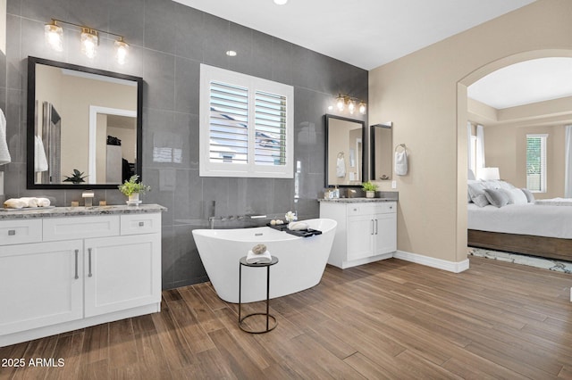 20151 E Via Del Palo St, Queen Creek, AZ 85142 - full bathroom with tile walls, two vanities, wood finished floors, and a freestanding tub