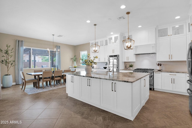 20151 E Via Del Palo St, Queen Creek, AZ 85142 - kitchen with high end stove, a chandelier, decorative backsplash, dark stone counters, and recessed lighting