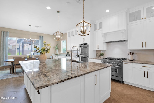 20151 E Via Del Palo St, Queen Creek, AZ 85142 - kitchen featuring appliances with stainless steel finishes, a chandelier, tasteful backsplash, custom exhaust hood, and a kitchen island with sink