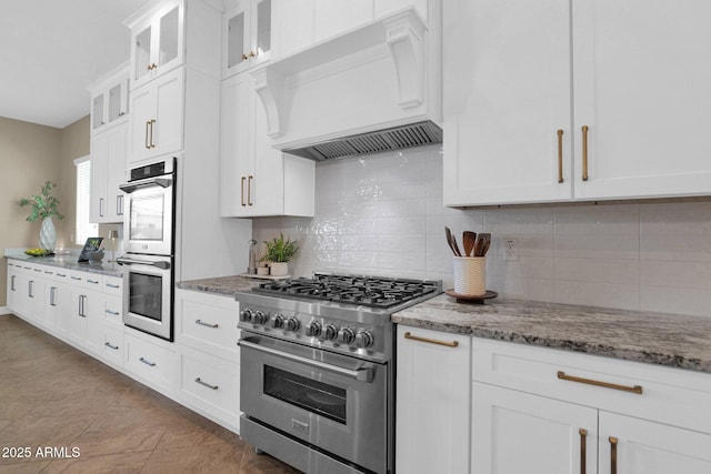 20151 E Via Del Palo St, Queen Creek, AZ 85142 - kitchen featuring appliances with stainless steel finishes, custom exhaust hood, light stone countertops, white cabinets, and backsplash