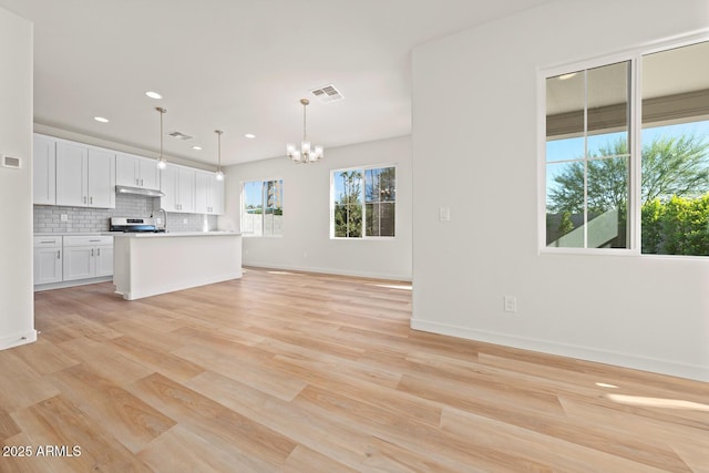 kitchen with pendant lighting, light countertops, visible vents, open floor plan, and white cabinetry