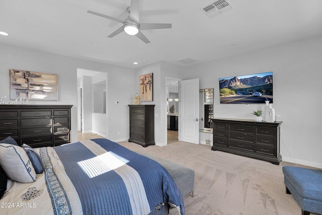 bedroom featuring ceiling fan, light colored carpet, and connected bathroom