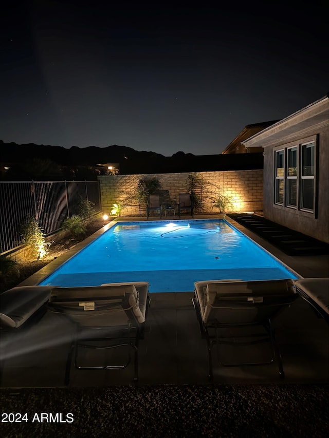 view of pool at twilight