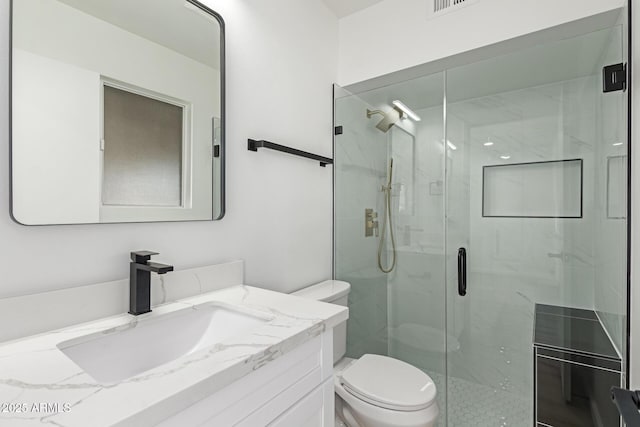 bathroom with toilet, a stall shower, and vanity
