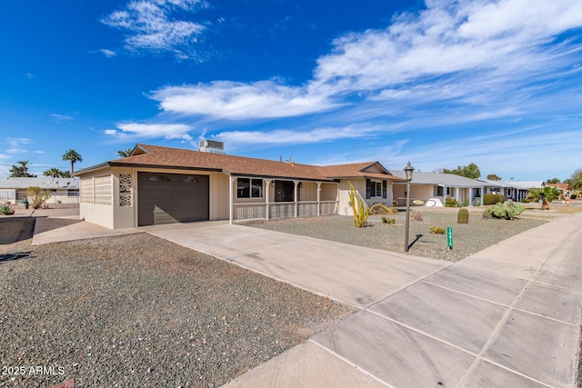 ranch-style house featuring driveway, an attached garage, and a residential view