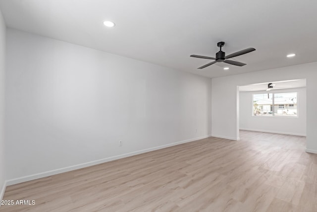 spare room featuring light wood-type flooring, baseboards, and recessed lighting