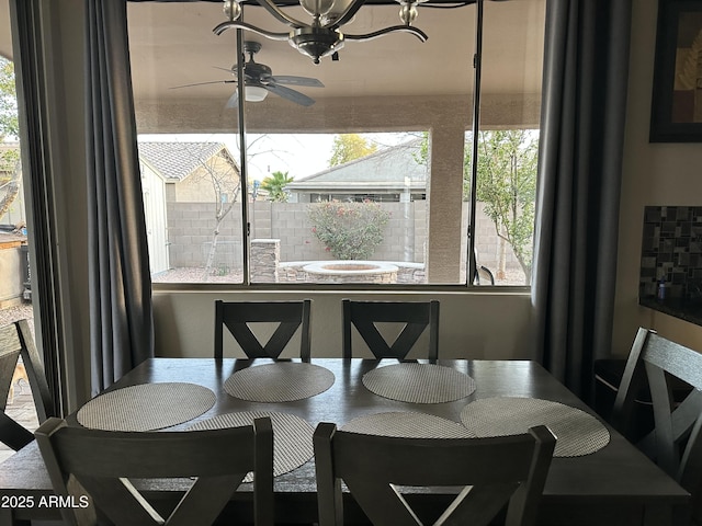 dining area featuring ceiling fan with notable chandelier