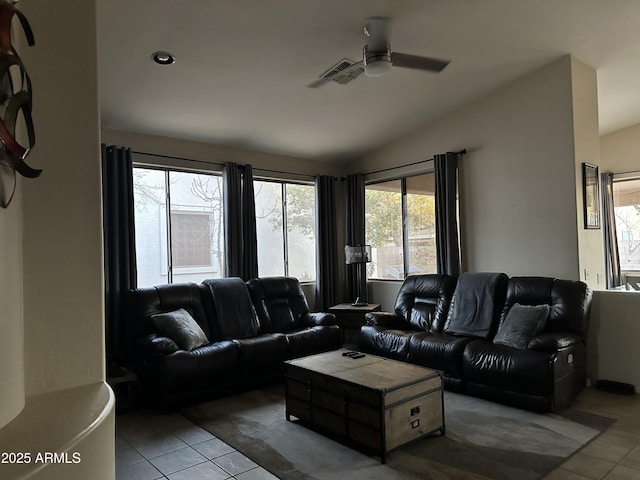 living room with ceiling fan, vaulted ceiling, and light tile patterned floors