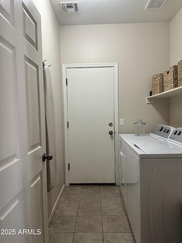 laundry area with washer and dryer and light tile patterned flooring