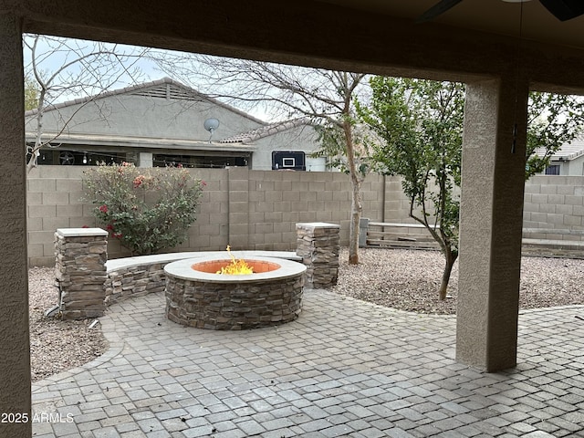 view of patio with ceiling fan and an outdoor fire pit