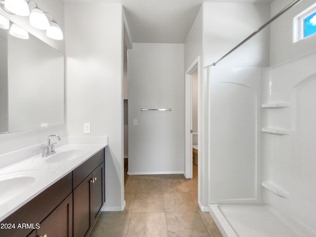 bathroom with tile patterned flooring, walk in shower, and vanity