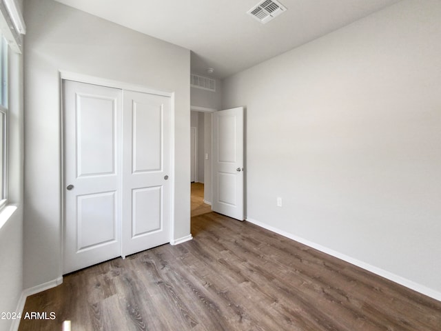 unfurnished bedroom with hardwood / wood-style floors and a closet