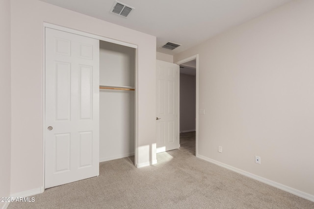 unfurnished bedroom featuring a closet and light colored carpet