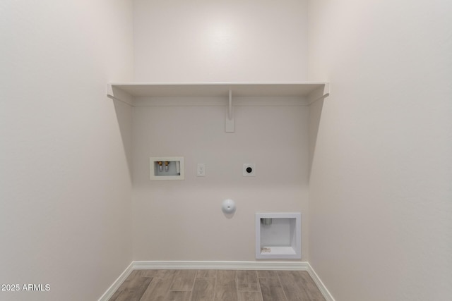 clothes washing area with hookup for a washing machine, electric dryer hookup, light hardwood / wood-style floors, and gas dryer hookup