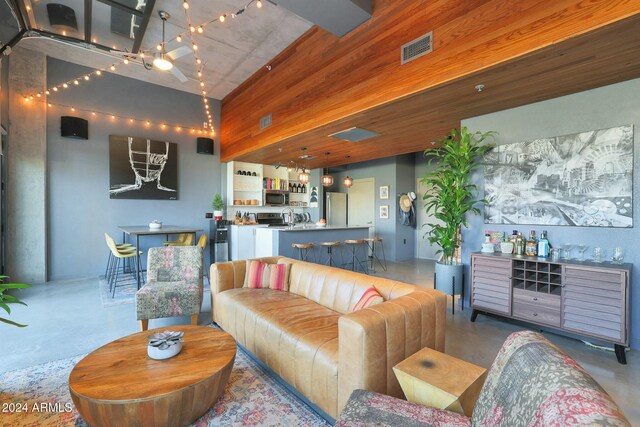 living room featuring wood walls and a towering ceiling