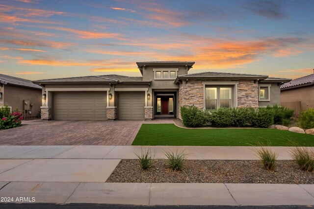 prairie-style house with a yard and a garage