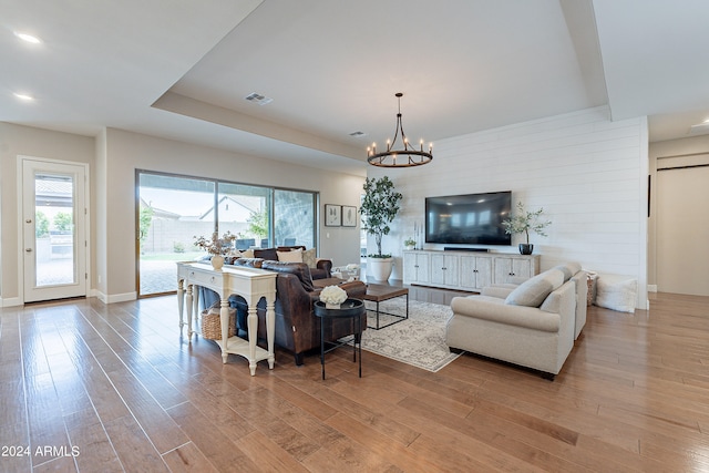 living room featuring light hardwood / wood-style flooring and a notable chandelier