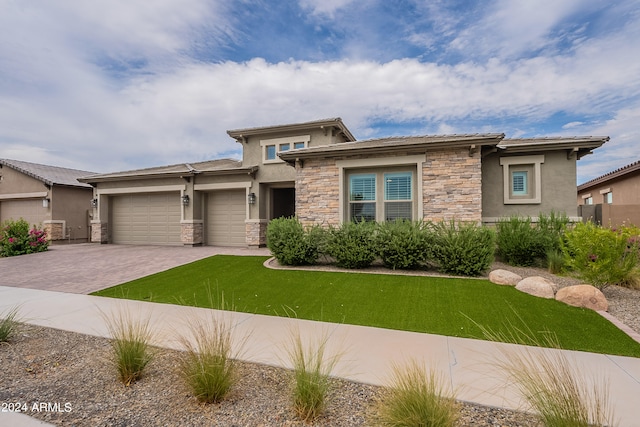 prairie-style house featuring a front lawn and a garage