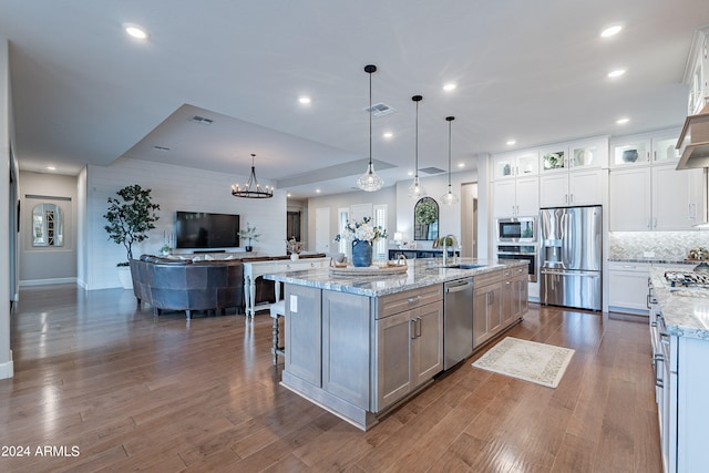 kitchen featuring appliances with stainless steel finishes, dark hardwood / wood-style flooring, white cabinetry, and a spacious island