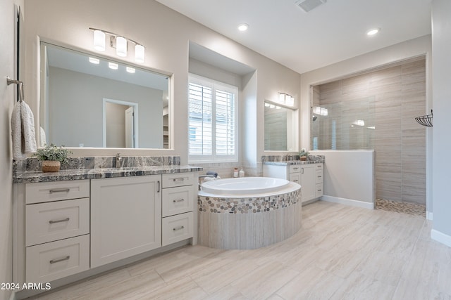 bathroom featuring tile patterned flooring, separate shower and tub, and vanity