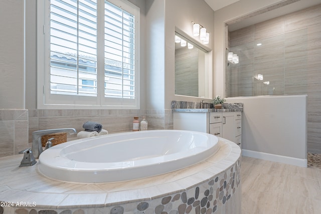 bathroom featuring vanity, hardwood / wood-style floors, and shower with separate bathtub