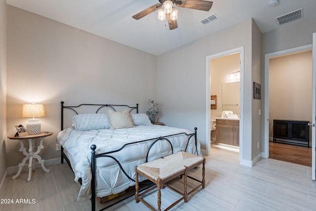 bedroom with ceiling fan, light wood-type flooring, and ensuite bathroom