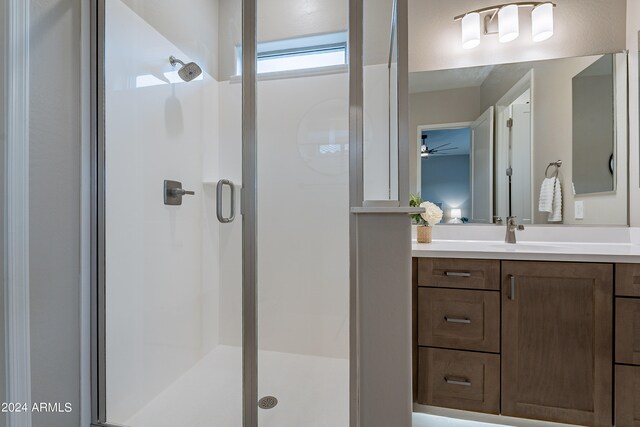 bathroom with a shower with door and vanity