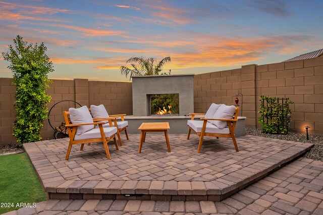 patio terrace at dusk with exterior fireplace