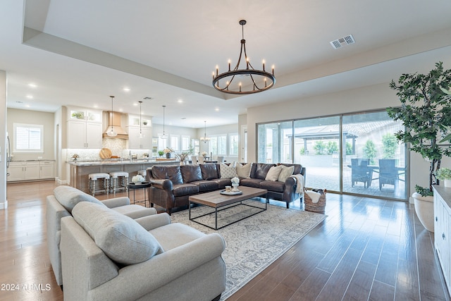 living room featuring a notable chandelier and light hardwood / wood-style flooring