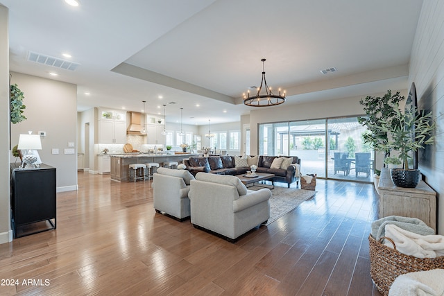 living room featuring sink, hardwood / wood-style floors, and a chandelier