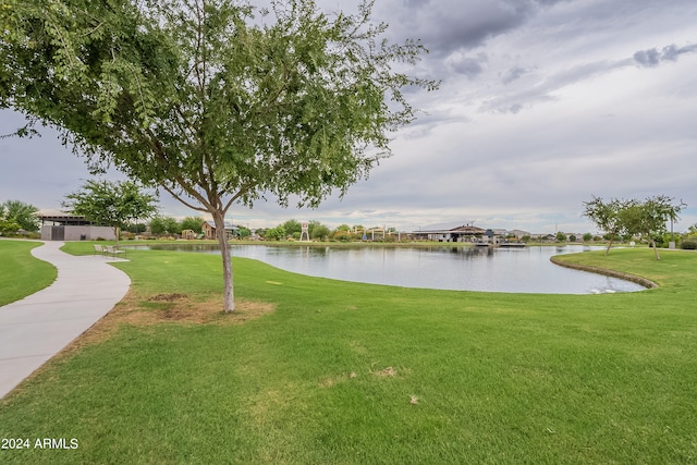 view of property's community with a lawn and a water view