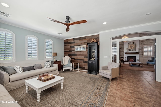 tiled living area with crown molding, a ceiling fan, visible vents, and a healthy amount of sunlight