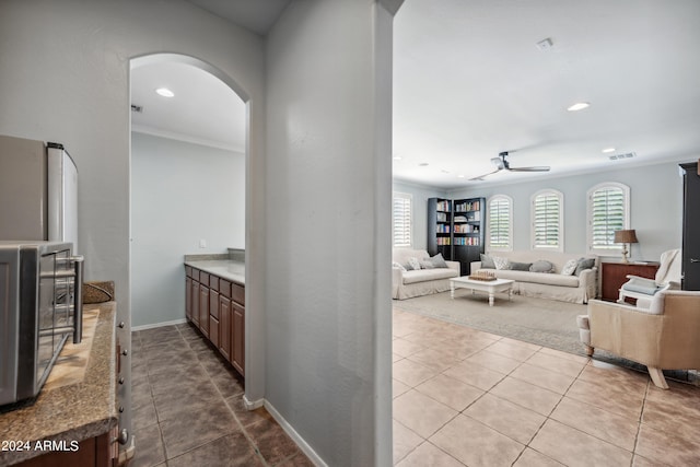corridor featuring crown molding, arched walkways, recessed lighting, and visible vents